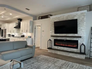 Close-up of a luxury media wall with electric fireplace and custom stone finish